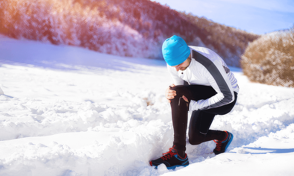 Man experiencing knee pain in the snow