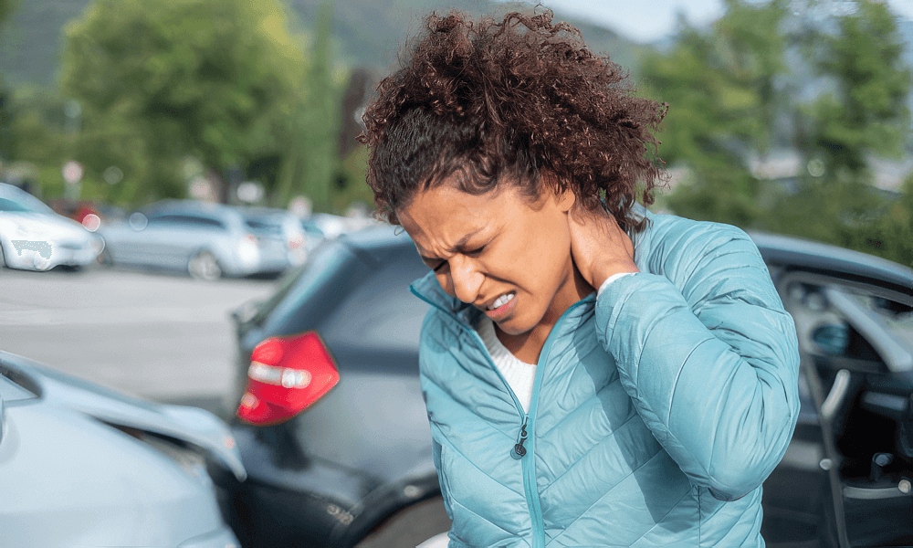 A woman experiencing neck pain after a car accident