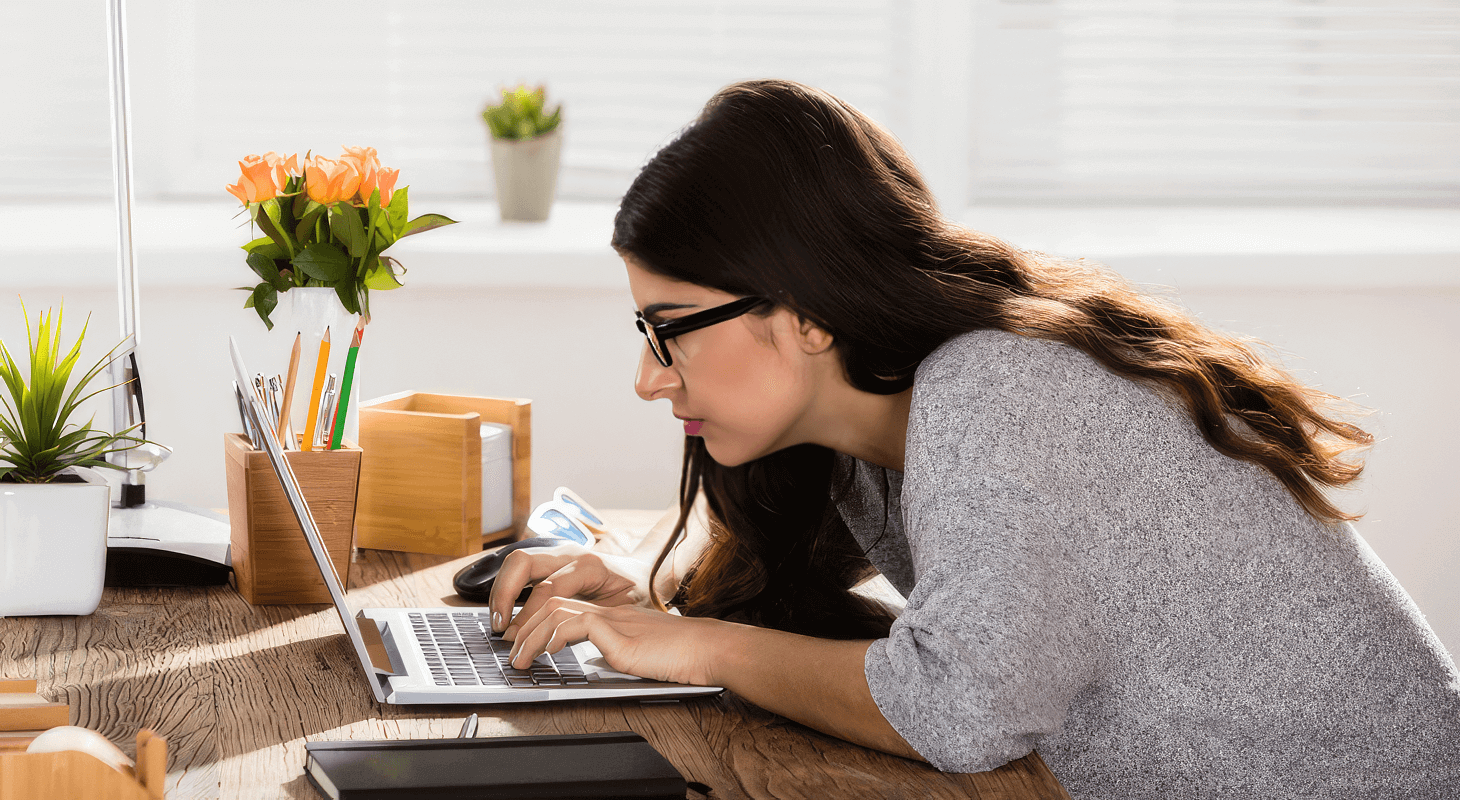 Woman leans over desk